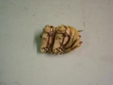 A Carved Ivory Brooch Formed as two horse heads with yellow metal bridles