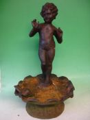 Garden Statuary A cast iron putto, standing on a seashell with a dove. 24