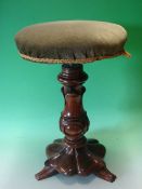 A Victorian Walnut Piano Stool. The screw adjusting over-stuffed seat raised on a lappet moulded