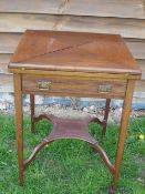 An Edwardian Mahogany Card Table. The envelope top over a channel moulded frieze drawer, raised on