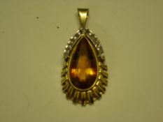 A Modernist Pendant in 14ct gold, set with a large pear shaped topaz and surmounted by thirteen