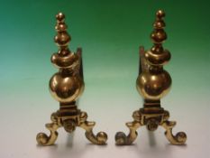 A Pair of Brass Fire dogs each moulded with a lion mask. 14 ¾