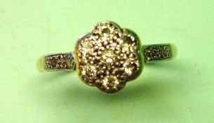 A Diamond Cluster Ring With seven diamonds in a flower form platinum setting, two old cut diamonds