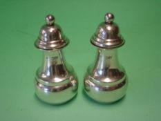 A Pair of Silver Pepperettes The domed covers with ball finials. 3 ¼