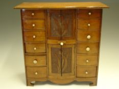 A Walnut Jewellery Chest With two flights of six drawers flanking two cabinets each enclosed by a