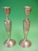 A Pair of Continental Silver Candlesticks With engraved foliate decoration to circular stepped foot,