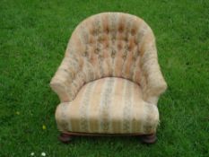 A Victorian Child's Armchair Of tub form, with deep buttoned back, raised on turned walnut feet.