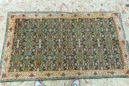 A small green ground rug or runner, 190c