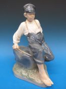 A Royal Copenhagen figure of a boy on a
