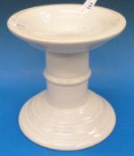 A circular ceramic ham stand