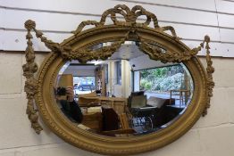 A large oval gilt framed mirror with orn