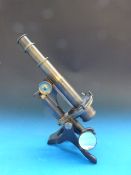 A 19thC brass microscope by Baker, 244 H