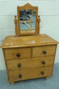 A small pine chest of drawers with swing