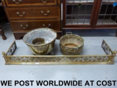 A brass fire fender with fleur de lys pi