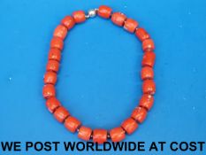 A coral necklace with barrel-shaped bead