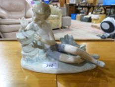A Lladro figure of a boy watching a bird