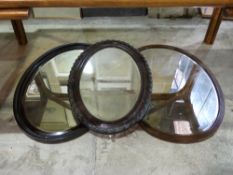 Three various oval framed mirrors