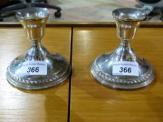 A pair of white metal candlesticks marke