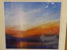 A large framed print of a sunset