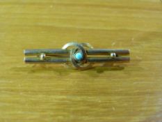 A yellow metal brooch with central pale