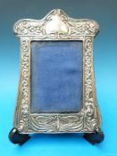 A silver Art Nouveau photograph frame wi