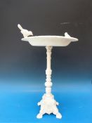 A painted cast metal bird bath with two