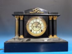 A slate mantel clock with Romanesque pil