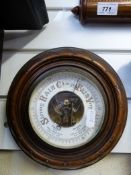A circular mahogany aneroid wall baromet