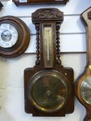 An oak carved aneroid barometer with the