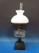 A cast iron and glass oil lamp