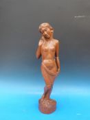 A carved hardwood figure of a semi-clad