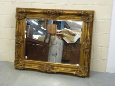 A very large gilded ornamental mirror wi