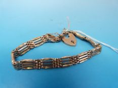 A yellow metal gate bracelet marked 9ct