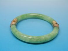 A jade or jadeite bangle with hinged yel