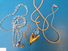 A silver chain with faux pearl pendant,