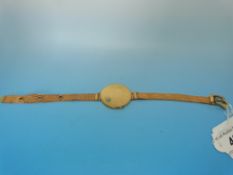 A yellow metal wrist locket set with a t