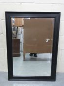 A black framed mirror with bevelled glas