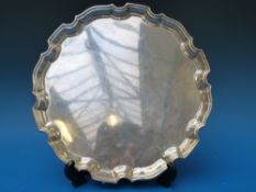 A hallmarked silver salver raised on thr