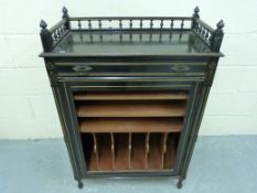 A late 19thC ebonised and gilt music cab