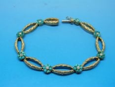 A yellow metal bracelet set with eight t