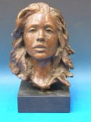 A bronze bust of a young girl signed VR