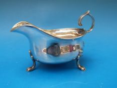 A hallmarked silver sauce boat raised on