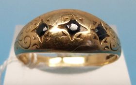 A yellow metal ring set with three sapph