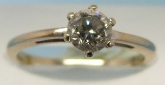 A yellow metal ring set with a round bri