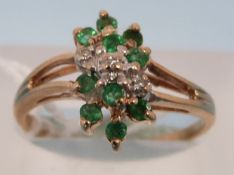 A 9ct gold ring set with diamonds and em