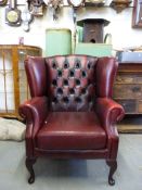 A red leather Chesterfield wing back arm