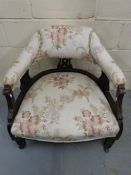 A 19thC upholstered tub chair raised on
