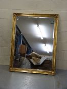 A large gilded mirror with bevelled glas