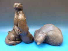 A resin model of two otters together wit