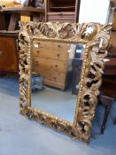 A gilt cushion framed mirror together wi